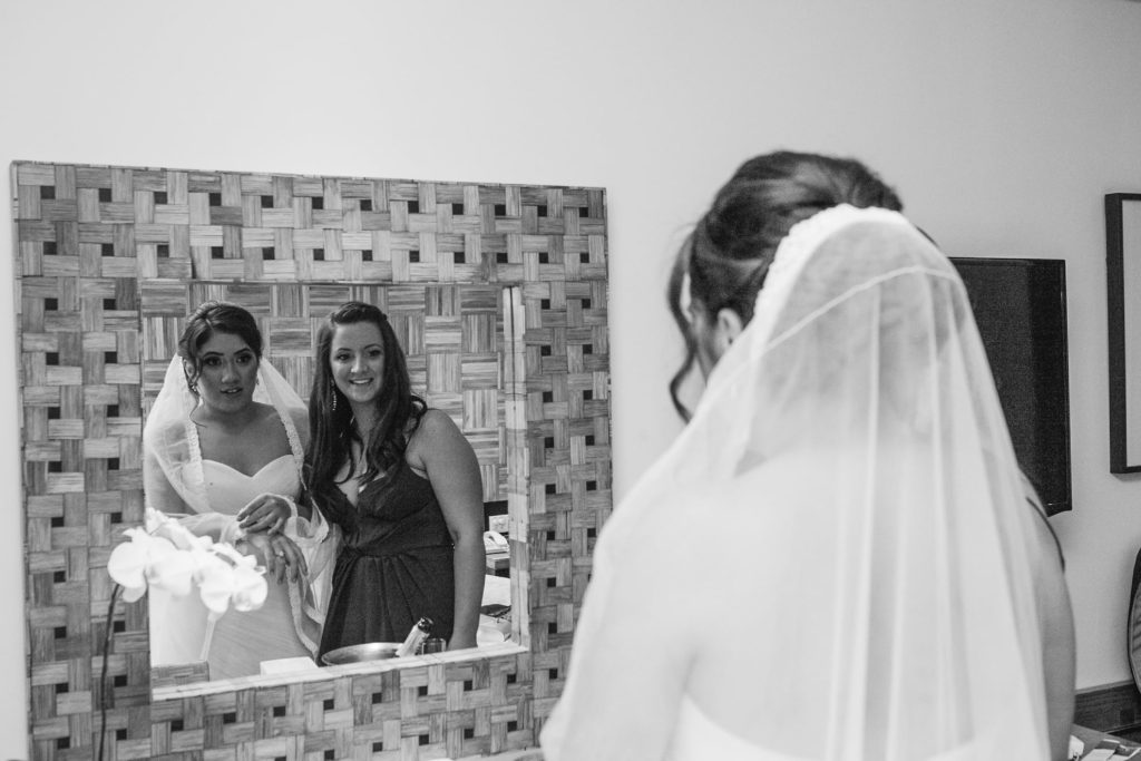 Image of Bride and Bridesmaid looking in the mirror - Beach Wedding with White Strapless White Wedding Dress